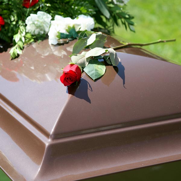 brown casket with rose on top